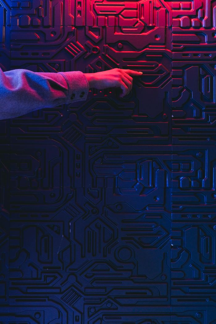 A person's hand interacting with a glowing circuit board, creating a modern tech ambiance.